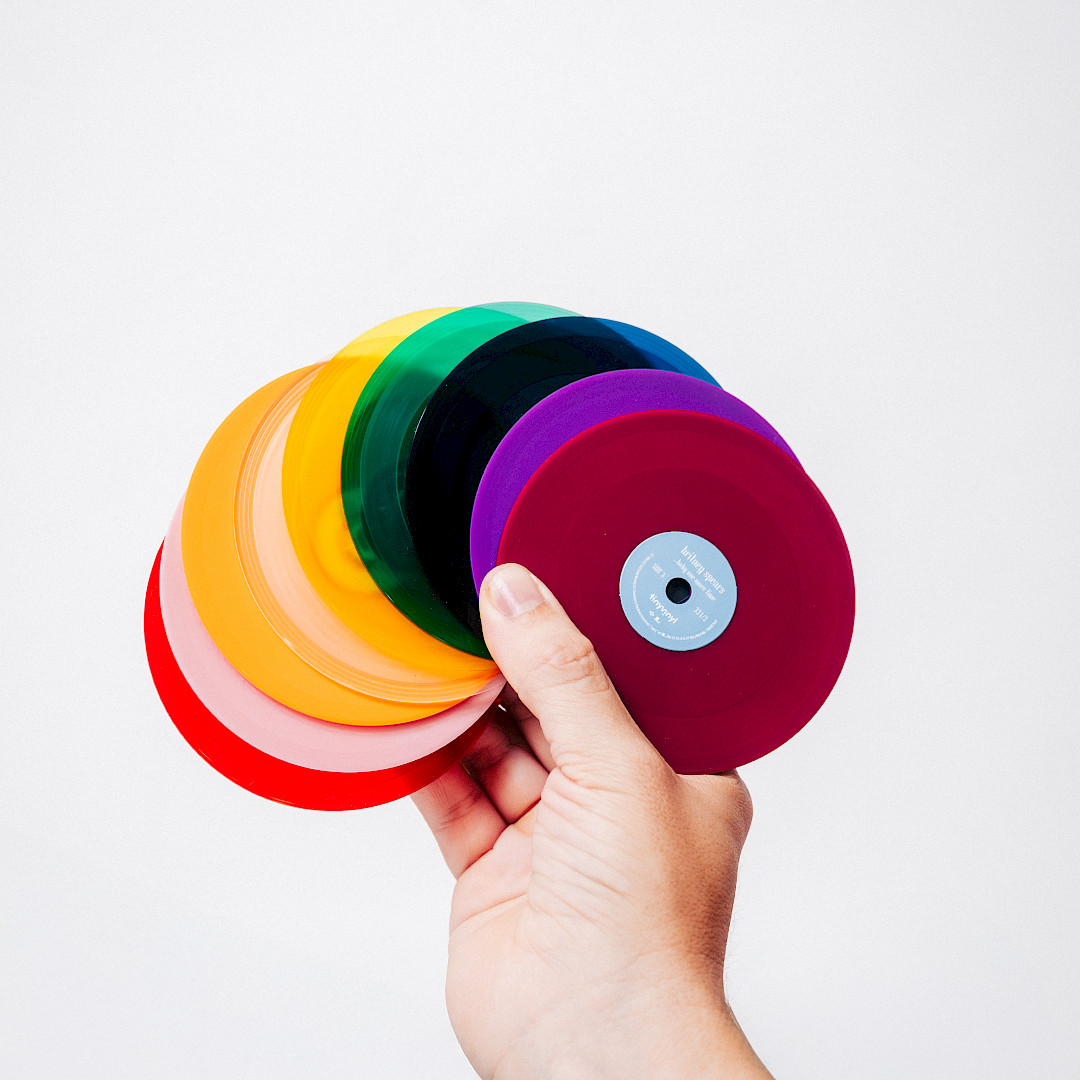 Hand holding different colour variants of tiny vinyl products